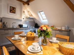 a kitchen with a wooden table with a vase of flowers at Holiday Home Tante Agnes by Interhome in Ediger-Eller