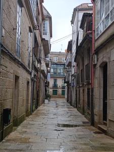 an empty street in an alley between buildings at A Barca de Pedra in Padrón