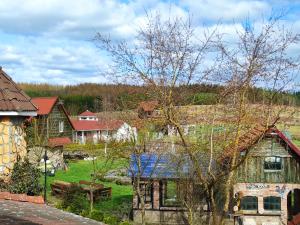 a group of houses in a yard with a tree at Siedem Ogrodów - Pokoje w Domku Kucharza in Łowicz Wałecki