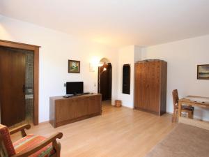 een woonkamer met een tv en een houten vloer bij Apartment Römerhof-3 by Interhome in Fügen +34 foto's