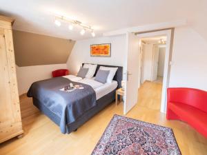 sypialnia z łóżkiem i czerwonym krzesłem w obiekcie Holiday Home Jula by Interhome w mieście Ediger-Eller