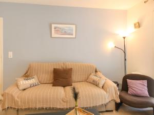 sala de estar con sofá y silla en Apartment Couleurs Tchanquées-2 by Interhome, en Arcachon