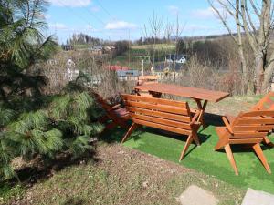 a picnic table and two wooden benches in a yard at Holiday Home Holiday Hill 67 by Interhome in Lauterwasser