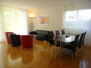 een woonkamer met een tafel en stoelen en een bank bij Apartment Bellevue-Park B 138 by Interhome in Engelberg