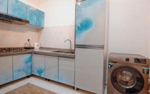 eine Küche mit Waschmaschine in der Unterkunft Big chill stays in Maijaw