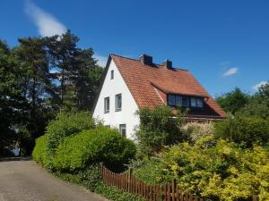 uma casa branca com um telhado vermelho em Fewo Am Heidestrandbad em Hemmoor