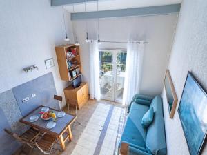 a living room with a blue couch and a table at Apartment Le Paradou-4 by Interhome in Rayol-Canadel-sur-Mer