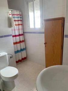 a bathroom with a toilet and a shower curtain at UNIFAMILIAR SIERRA DE CADIZ in El Bosque