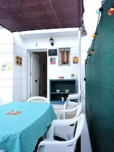 UNIFAMILIAR SIERRA DE CADIZ في البوسكي: غرفة طعام مع طاولة زرقاء وكراسي بيضاء