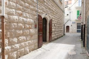 een steegje met een bakstenen muur en twee deuren bij Sottano del Mastro Central Apartment in Corato