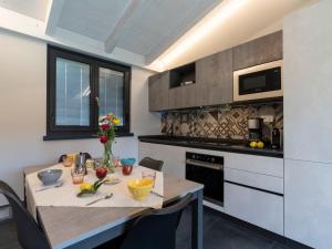 eine Küche mit einem Holztisch sowie einem Tisch und Stühlen in der Unterkunft Apartment Al Bistrot dei Vinai-4 by Interhome in Imperia