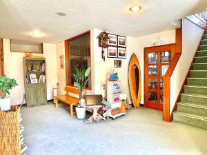 a room with a staircase and a desk with a laptop at タートルハウス in Shimoda