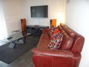 ein Wohnzimmer mit einem braunen Ledersofa und einem Tisch in der Unterkunft Apartment Bellevue-Park B 145 by Interhome in Engelberg