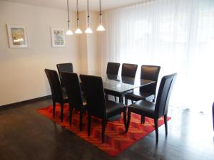 ein Esszimmer mit einem schwarzen Tisch und schwarzen Stühlen in der Unterkunft Apartment Bellevue-Park B 145 by Interhome in Engelberg