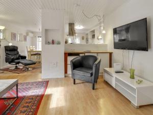 a living room with a tv and a chair and a table at Holiday Home Josina - 32km from the sea in Western Jutland by Interhome in Esbjerg