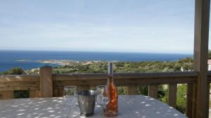 a bottle of wine sitting on a table on a balcony at CAMPING MONTE ORTU in Lumio