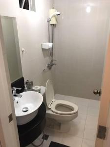 a bathroom with a white toilet and a sink at Casa Antonio at Stamford McKinley Hill Unli Wi-Fi Near Piazza in Manila