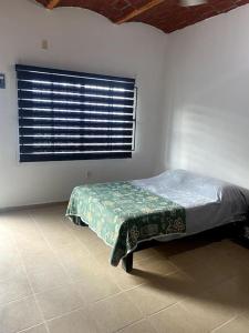 - une chambre avec un lit dans une pièce dotée d'une fenêtre dans l'établissement Tropico Cabana, à Rincon de Guayabitos