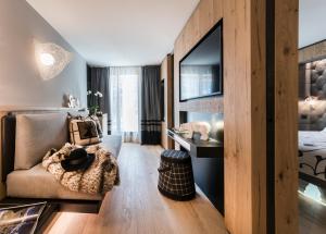 un soggiorno con un divano e una TV di Majestic Hotel a Madonna di Campiglio