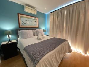 una camera da letto con un grande letto con pareti blu di Imany Guest House a Bloubergstrand