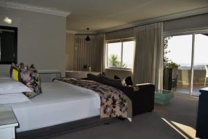 um quarto com uma cama grande e uma janela grande em Chocolate Box Guesthouse em Gordonʼs Bay