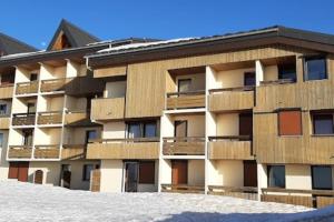 an apartment building with wooden balconies in the snow at Samoens 1600 les cimes in Samoëns