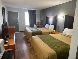 a hotel room with two beds and a desk at Rodeway Inn in Hopkinsville