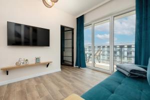 ein Wohnzimmer mit Couch und großem Fenster in der Unterkunft Apartament LAZUROWY Bridge Apartments & Spa z basenem Dziwnów EPapartamenty in Dziwnów