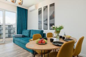 ein Wohnzimmer mit einem Tisch und einem blauen Sofa in der Unterkunft Apartament LAZUROWY Bridge Apartments & Spa z basenem Dziwnów EPapartamenty in Dziwnów
