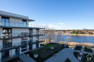 ein Apartmenthaus mit Flussblick in der Unterkunft Apartament LAZUROWY Bridge Apartments & Spa z basenem Dziwnów EPapartamenty in Dziwnów