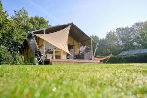 ein Haus mit einem Zelt auf einem Grasfeld in der Unterkunft Glamping Twente in Denekamp