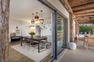 ein Esszimmer mit einem Tisch und Stühlen sowie ein Zimmer mit einem Fenster in der Unterkunft Casa Ciudamar Costa Brava - BY EMERALD STAY in Begur