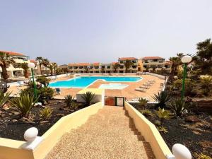 a large swimming pool in a resort with palm trees at Puskas Apartman in Costa de Antigua