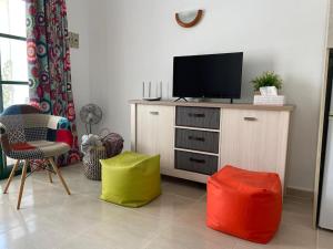 uma sala de estar com televisão numa cómoda com duas lontras coloridas em Puskas Apartman em Costa de Antigua