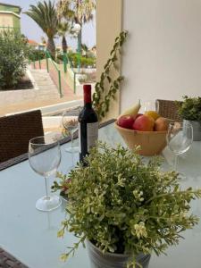 a table with a bottle of wine and a bowl of fruit at Puskas Apartman in Costa de Antigua