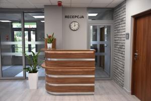 an office lobby with a reception desk and a clock at Pokoje Gościnne MODR 