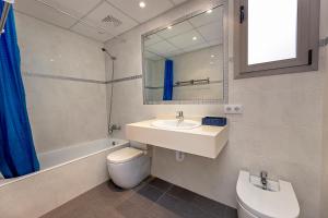 y baño con lavabo, aseo y espejo. en Apartamento GAVINA 1C - a 400m de la playa, en Pollensa