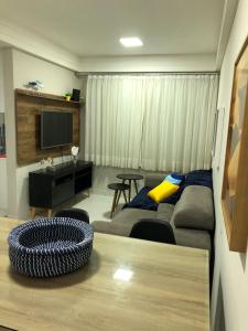 a living room with a couch and a tv at Cobertura Armação in Salvador