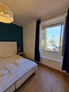 a bedroom with a bed and a large window at Butterfly Accommodation in Alghero
