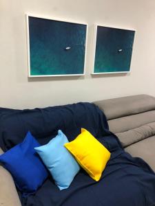 Un sofá azul con cuatro almohadas. en Cobertura Armação, en Salvador