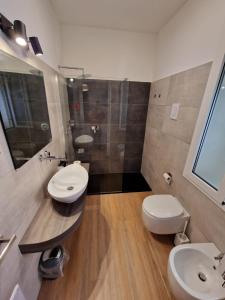 a bathroom with two sinks and a shower and a toilet at Butterfly Accommodation in Alghero