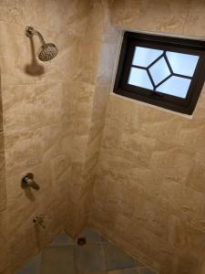 a bathroom with a shower with a window at Valentier Cafe and Hotel in Chiang Mai