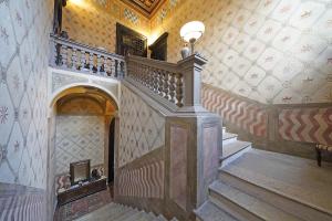 a staircase in a building with a wall at Foresteria Palazzo Guazzoni Zaccaria in Cremona