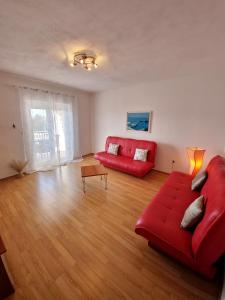 sala de estar con sofá rojo y mesa en Apartments Cacija, en Trogir