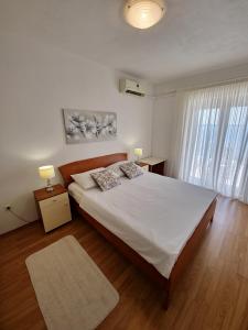 a bedroom with a large bed and a large window at Apartments Cacija in Trogir