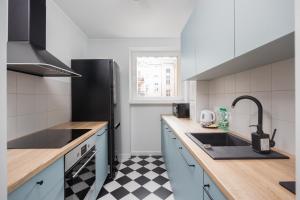 a kitchen with a black and white checkered floor at Śródmieście Homely Apartment in Warsaw