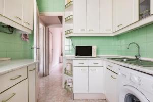 a kitchen with white cabinets and a sink and a microwave at Mi descanso in Madrid