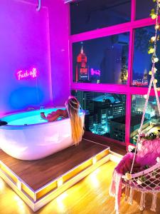 a girl laying in a bath tub in a room with a window at Experience 41 in Sao Paulo