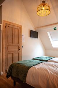 Schlafzimmer mit einem Bett und einem Kronleuchter in der Unterkunft Kerkdreef8 in Merkem
