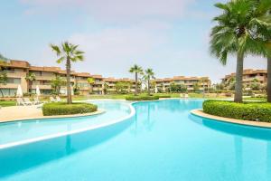 馬拉喀什的住宿－Résidence Golfique PJ, jardin, piscine，度假村内一座种有棕榈树的大型游泳池